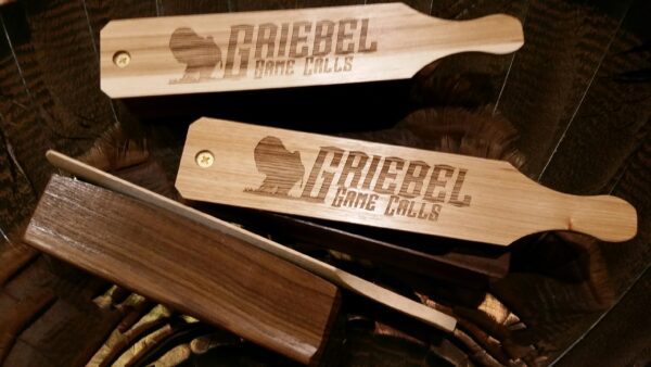 A close up of some wooden spoons with the name griebel game calls written on them.